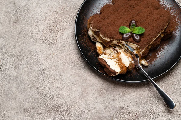 Portie van Classic tiramisu dessert op keramische plaat op beton achtergrond — Stockfoto