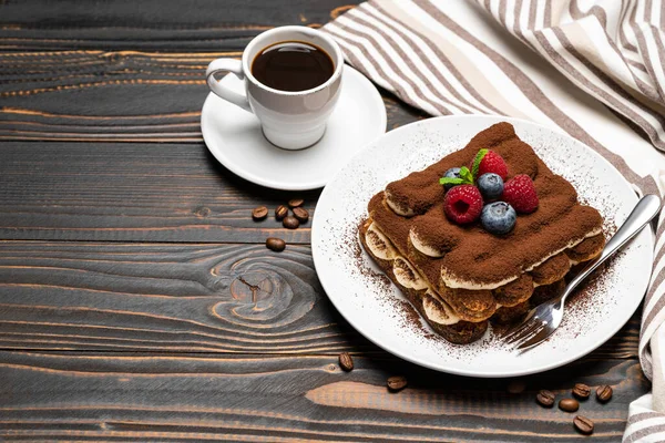 Portion klassisches Tiramisu-Dessert mit Himbeeren, Blaubeeren und Tasse Espresso isoliert auf Holzgrund — Stockfoto