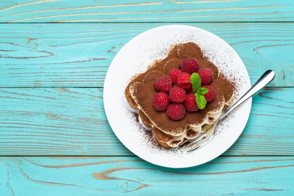 Egy adag klasszikus tiramisu desszert málna kék fa háttér — Stock Fotó