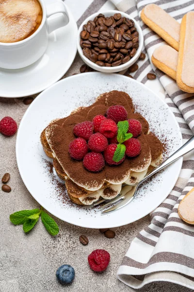 Egy adag klasszikus tiramisu desszert málnával és csésze kávé szürke beton háttér — Stock Fotó