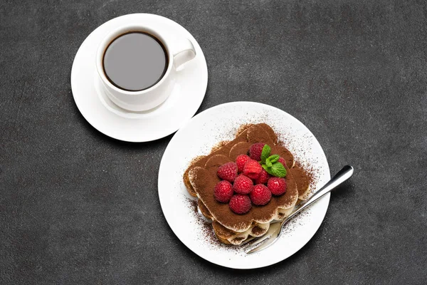 Часть классического десерта тирамису с малиной и чашкой кофе темно-бетонный фон — стоковое фото