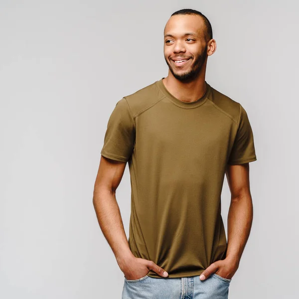穿着绿色T恤、身披浅灰色背景、带复印空间的快乐友善的非洲裔美国年轻人 — 图库照片