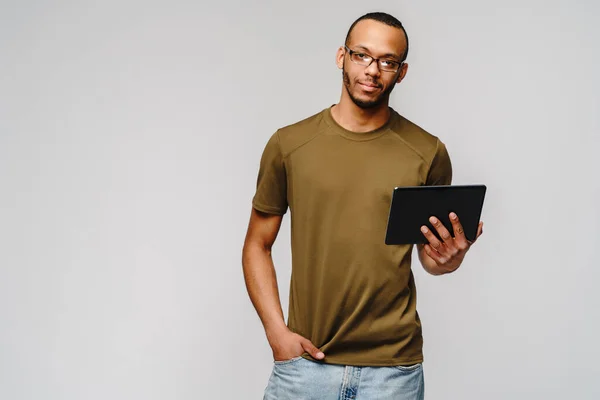 Ritratto di un giovane uomo afro-americano che indossa una t-shirt verde con in mano un blocco per tablet — Foto Stock