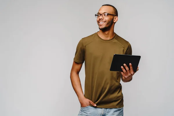 Ritratto di un giovane uomo afro-americano che indossa una t-shirt verde con in mano un blocco per tablet — Foto Stock