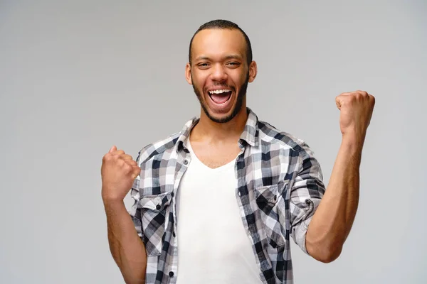 Jonge Afro-Amerikaanse man ja winnen gebaar over lichtgrijze achtergrond — Stockfoto