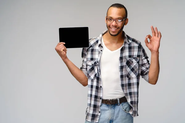 Porträt eines jungen afrikanisch-amerikanischen Mannes mit grünem T-Shirt und Tablet-PC-Pad — Stockfoto