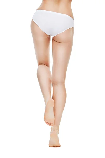 Belle gambe femminili con mutandine bianche su sfondo bianco — Foto Stock