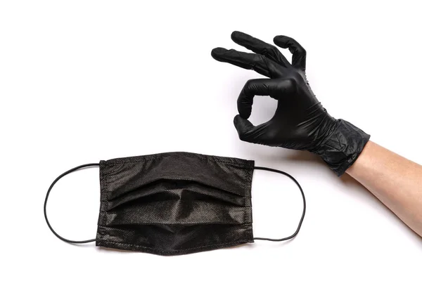 Menselijke hand in beschermende handschoen en gezicht beschermende maskers geïsoleerd op witte achtergrond — Stockfoto