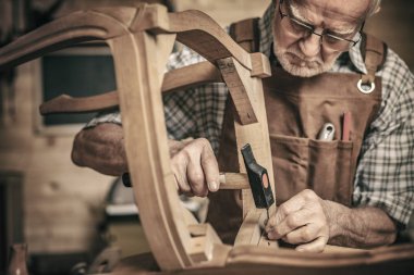 Yaşlı marangoz bir klasik stil sandalye oluşturur