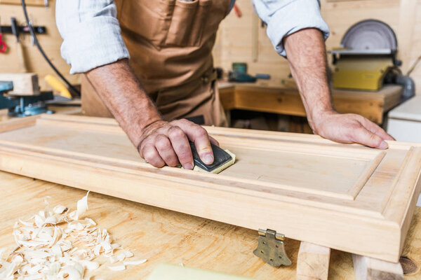 detail of caucasian carpenter at work in a workshop