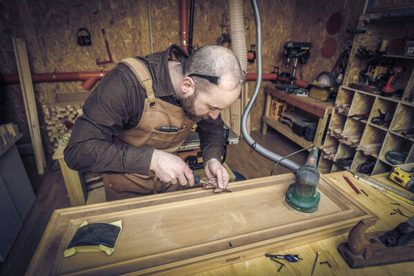 caucasian carpenter at work in his workshop