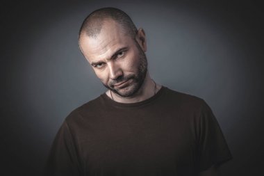 Kendine güvenen ve tehditkar bir görünüme sahip bir adamın portresi. 