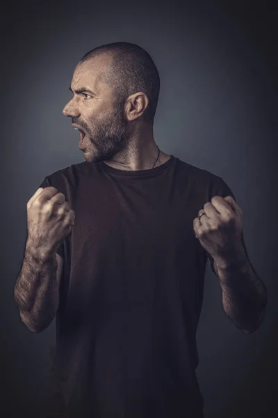 Satisfied man posing with clenched fists as a sign of success.