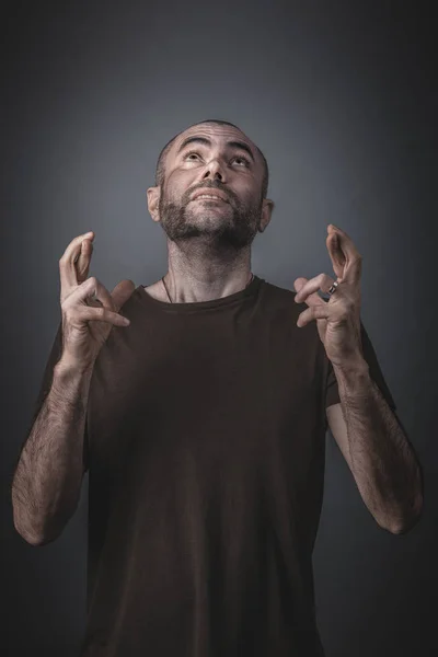 Portret van een man opzoeken en houden van zijn vingers gekruist. — Stockfoto
