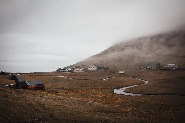 Fiume tortuoso e solitario villaggio costiero avvolto nella nebbia sul — Foto Stock