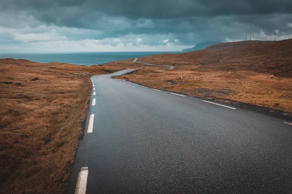 Vy över en enslig och slingrande väg på Färöarna — Stockfoto