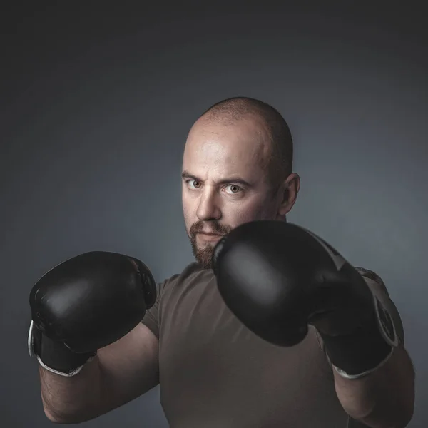 Hombre adulto con ropa casual y guantes de boxeo, mira directamente — Foto de Stock