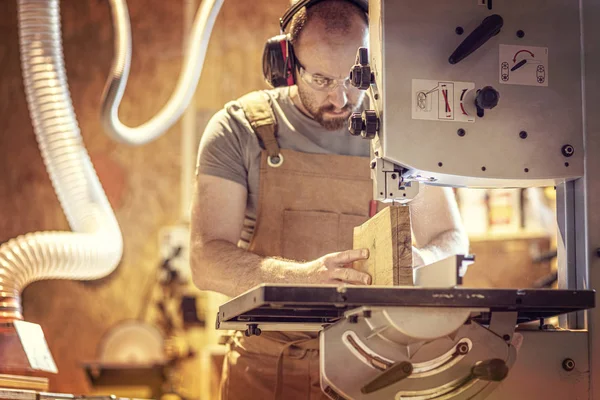 Retrato de um carpinteiro dentro de sua oficina de carpintaria usando um ba — Fotografia de Stock