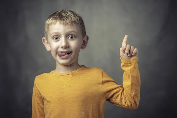 Funny portrait of a 6 year old Caucasian child with his tongue s — Stock Photo, Image