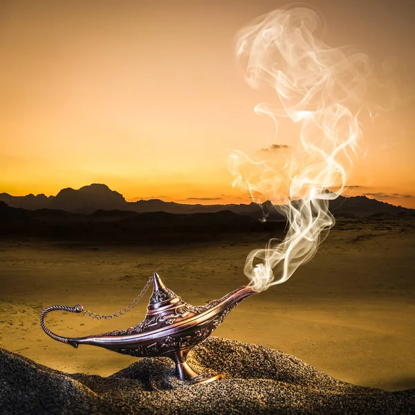 Classic gold-colored aladdin lamp laid on the sand of a dune wit — Stock Photo, Image