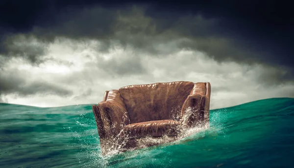 Kožené křeslo rozptýlené na vlnách moře. — Stock fotografie