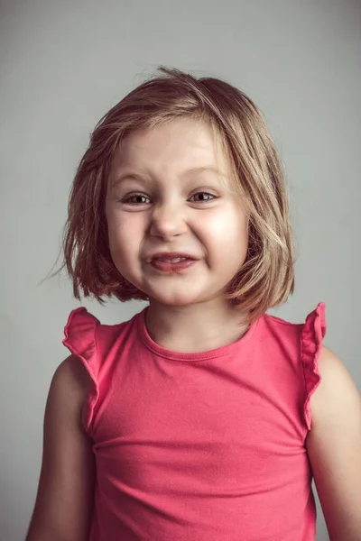金发碧眼的高加索小女孩做出了一张丑陋可笑的脸 工作室肖像 — 图库照片
