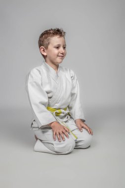 Çocuk Japon tarzında oturma pozisyonunda karate yapıyor. Stüdyo resmi