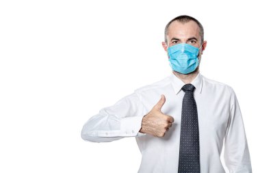 Coronavirus covid 19 virüsüne karşı korunmak için ameliyat maskesi. Beyazda izole. Başparmak yukarı.