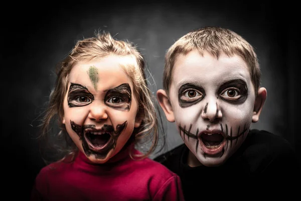 children with face made up for halloween party. studio shot.