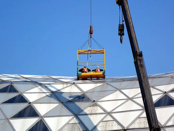 台湾高雄 2018年5月13日 被起重机吊起的工人视察高雄会展中心的屋顶 — 图库照片