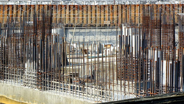 A large scale construction site with steel bars and concrete pillar