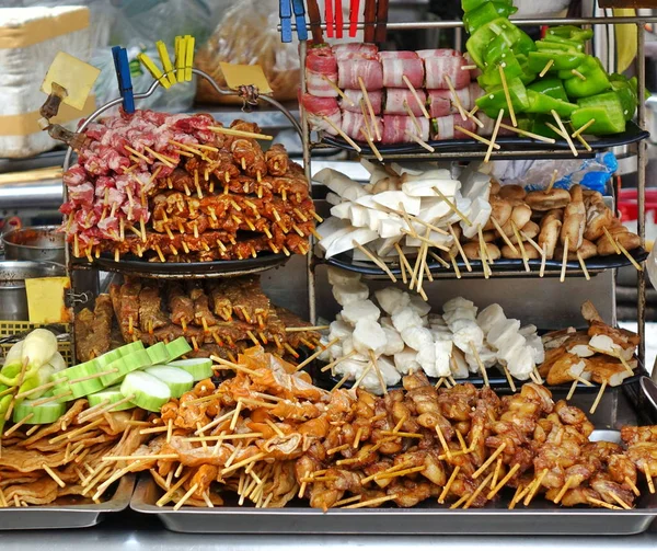 A street food stall in Taiwan offers a variety of meat and vegetable skewers