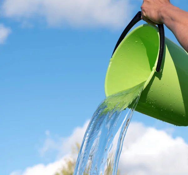 Verter Agua Cubo Contra Cielo Azul —  Fotos de Stock