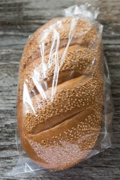 Pan Con Semillas Sésamo Bolsa Plástico Sobre Mesa —  Fotos de Stock