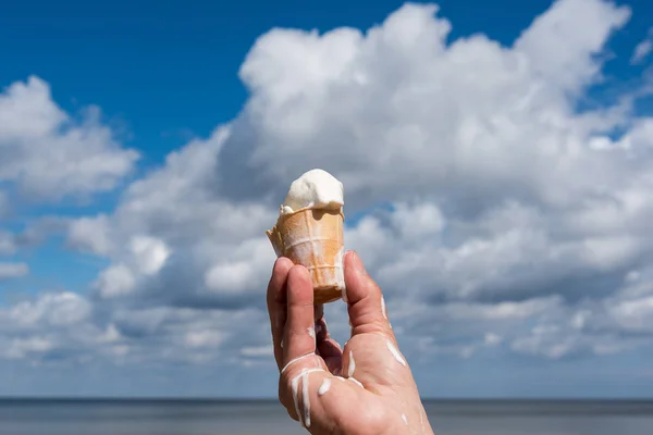 在背景多云天空融化冰淇淋手 — 图库照片