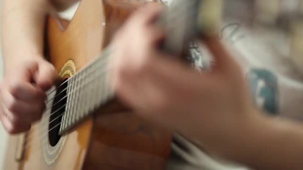 De gitarist speelt een akoestische gitaar. Gitarist hand en fretboard close-up — Stockvideo