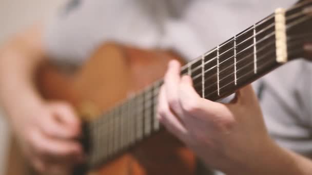 De gitarist speelt een akoestische gitaar. Gitarist hand en fretboard close-up — Stockvideo