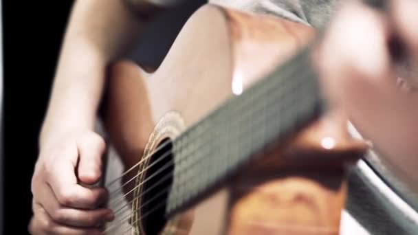 Il chitarrista suona una chitarra acustica. Primo piano chitarrista mano e tastiera — Video Stock