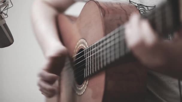 De gitarist speelt een akoestische gitaar. Gitarist hand en fretboard close-up — Stockvideo