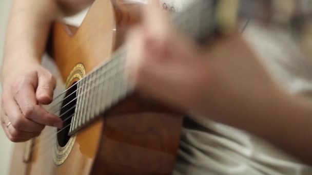 De gitarist speelt een akoestische gitaar. Gitarist hand en fretboard close-up — Stockvideo