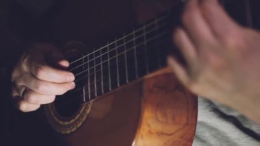 Gitarist adam karanlık romantik arka planda ışıklarla. Parmak stili tekniği