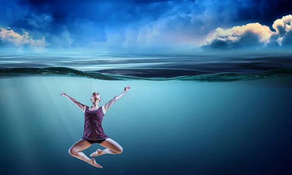 Woman dancer in clear blue water — Stock Photo, Image