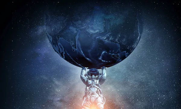 El hombre del espacio lleva un planeta grande. Medios mixtos — Foto de Stock
