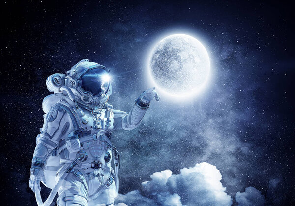 Astronaut pointing with finger on moon planet. Elements of this image furnished by NASA