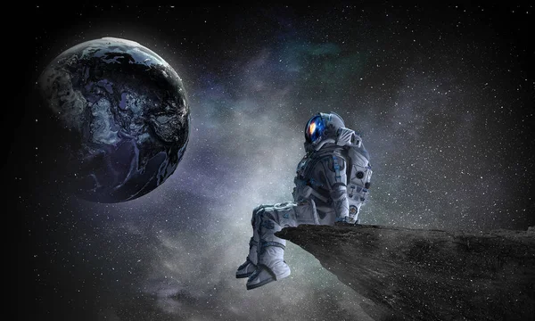 Spaceman on rock edge. Mixed media — Stock Photo, Image