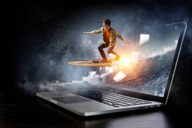 Laptop klavye üzerinde kaykay sürme genç adam. Karışık teknik