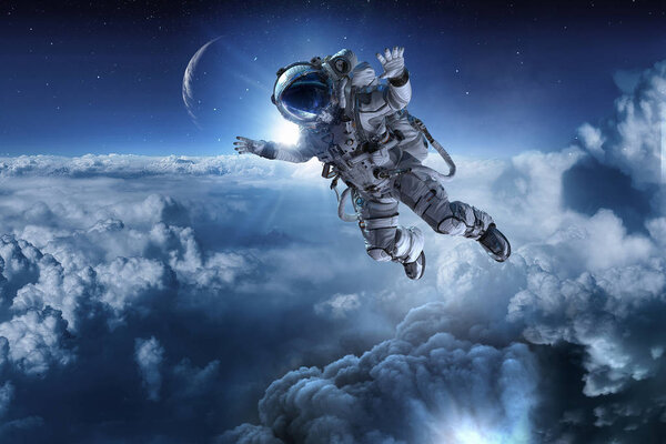 Astronaut fly in cloudy sky. Elements of this image furnished by NASA.