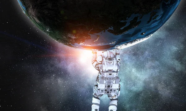 Raumfahrer tragen großen Planeten. Gemischte Medien — Stockfoto