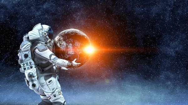 Διαστημάνθρωπου μεταφέρουν μεγάλο πλανήτη. Μικτή τεχνική — Φωτογραφία Αρχείου