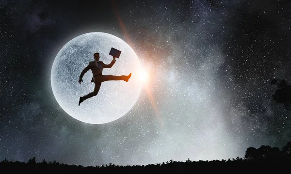 Silueta de hombre de negocios sobre la luna. Medios mixtos — Foto de Stock